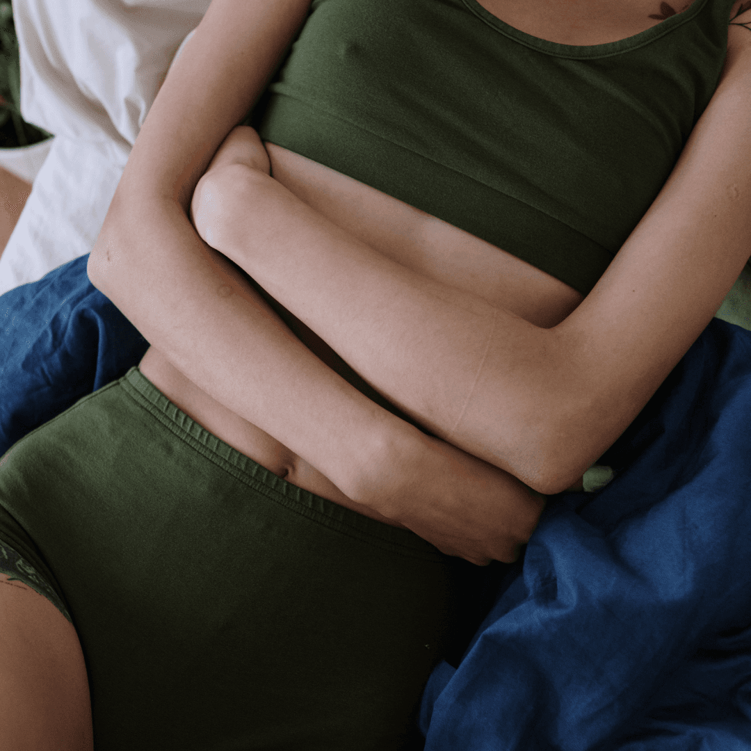 Woman hugging belly showing postpartum vulnerability