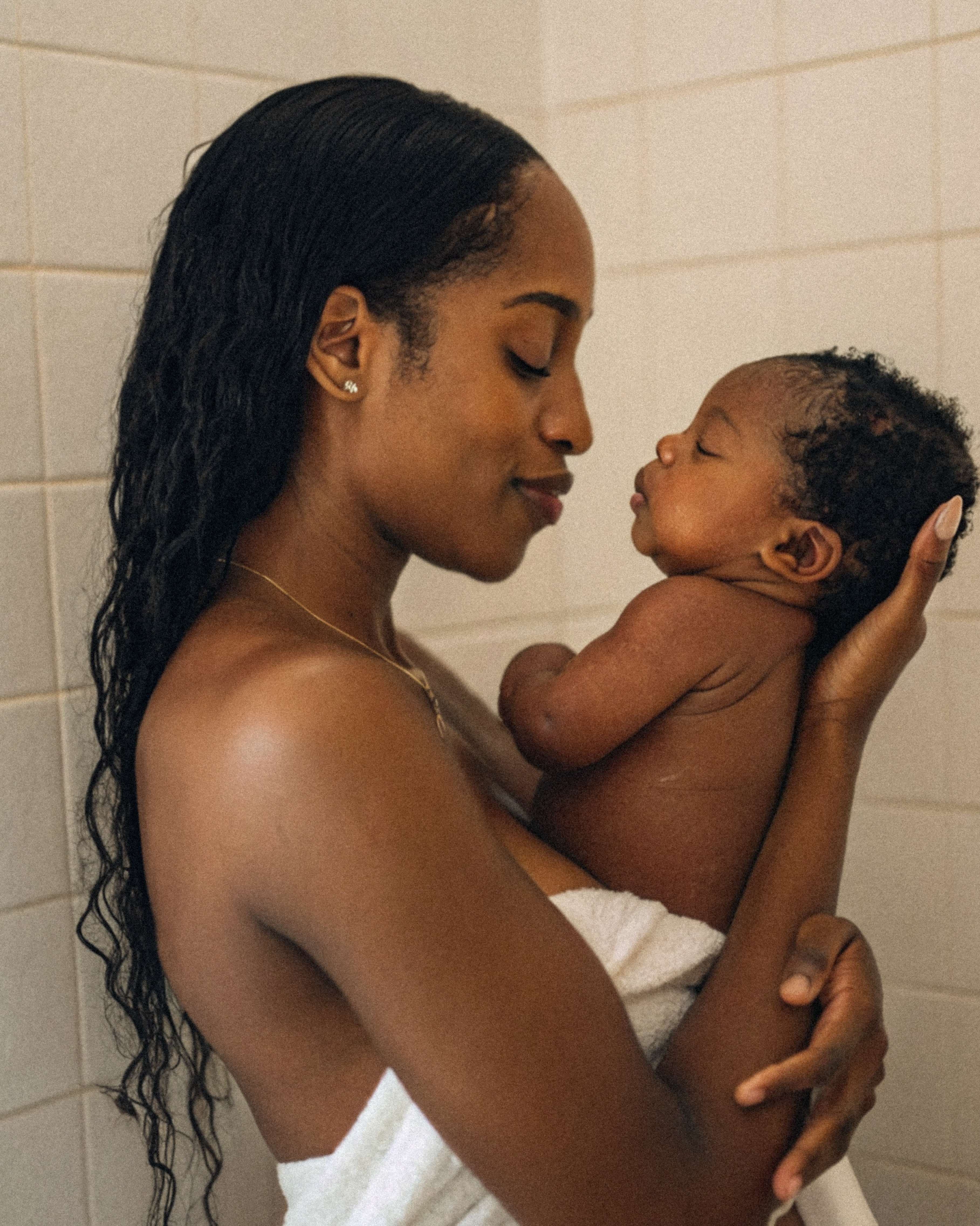 Mother holding newborn baby in warm intimate setting