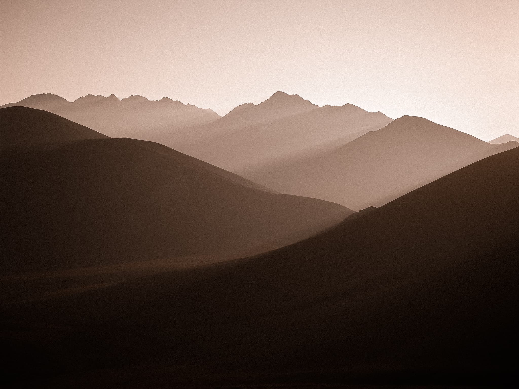 Warm mountain silhouettes at sunset evoking calm energy and renewal