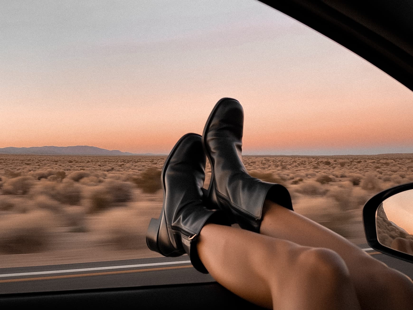 Smooth legs out a car window at golden hour, evoking the freedom of laser hair reduction