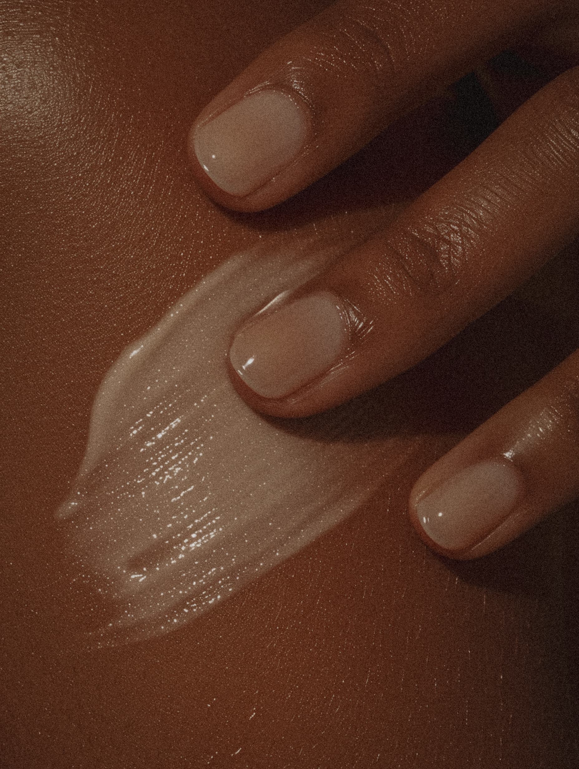 Close-up of fingers applying nourishing product to smooth skin after laser treatment